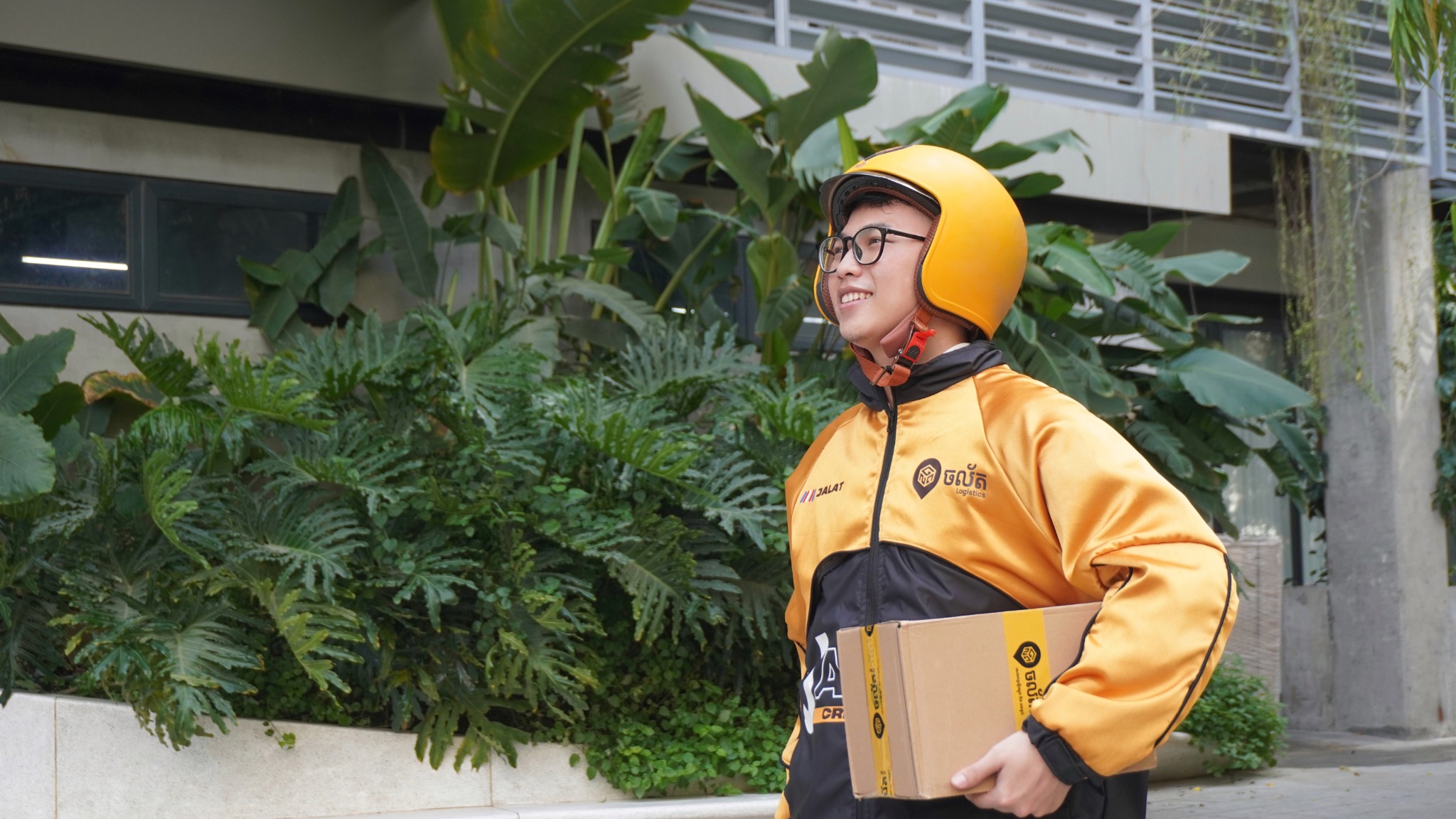 Jalat rider in the current yellow and black uniform carrying a parcel